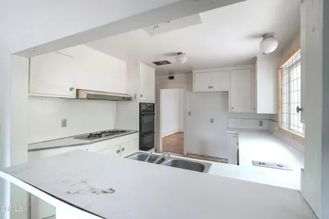 a view of a kitchen with a sink and cabinets
