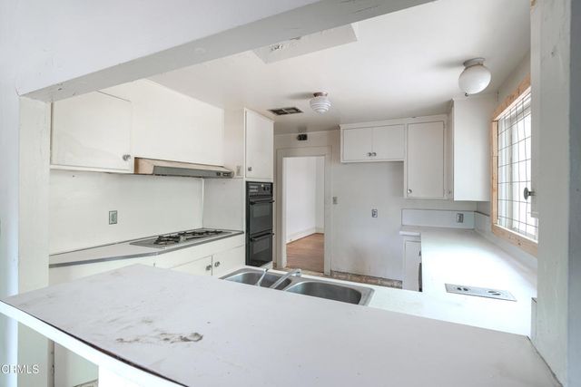 a view of a kitchen with a sink and cabinets