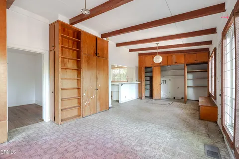 an empty room with closet and windows