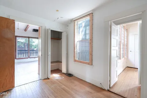 a view of an empty room with a window and wooden floor