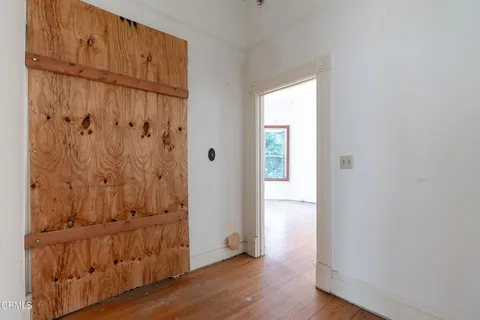 a view of an empty room with wooden floor
