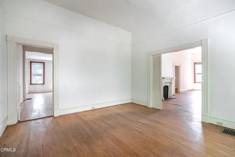 an empty room with wooden floor and a window