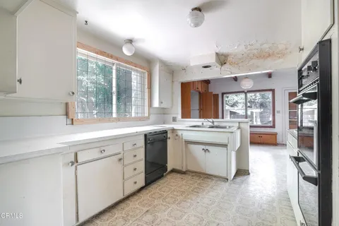 a large kitchen with a sink window and cabinets