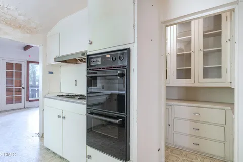 a kitchen with a stove oven and white cabinets
