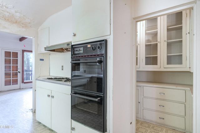 a kitchen with a stove oven and white cabinets