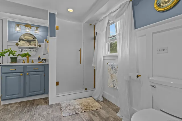 a bathroom with a granite countertop sink toilet and shower
