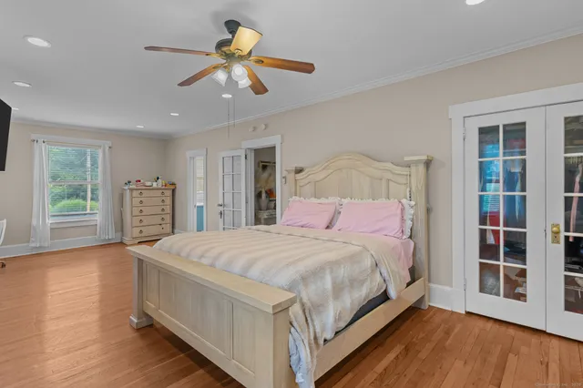 a bedroom with a large bed chandelier and a window