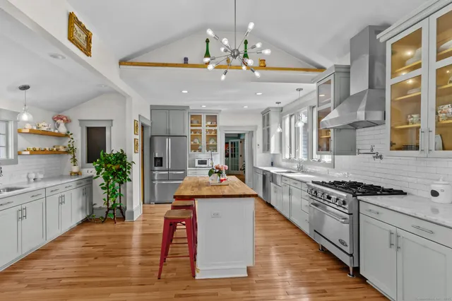 a large kitchen with stainless steel appliances granite countertop a stove and cabinets with wooden floor