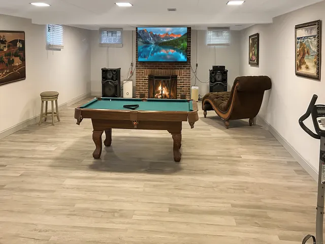 a living room with furniture a fireplace and paintings on wall