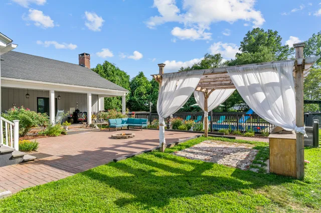 a view of a house with backyard and sitting area