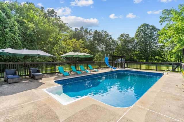 a view of swimming pool with chairs in patio
