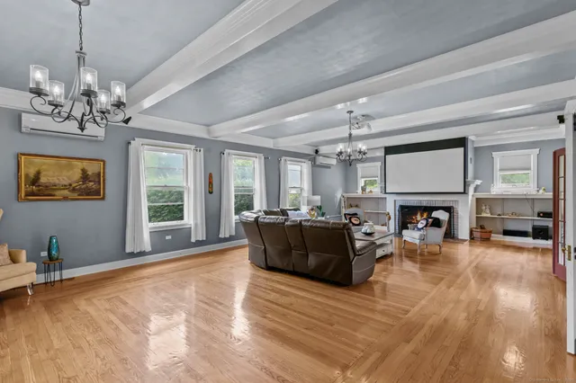 a living room with furniture a fireplace and a chandelier