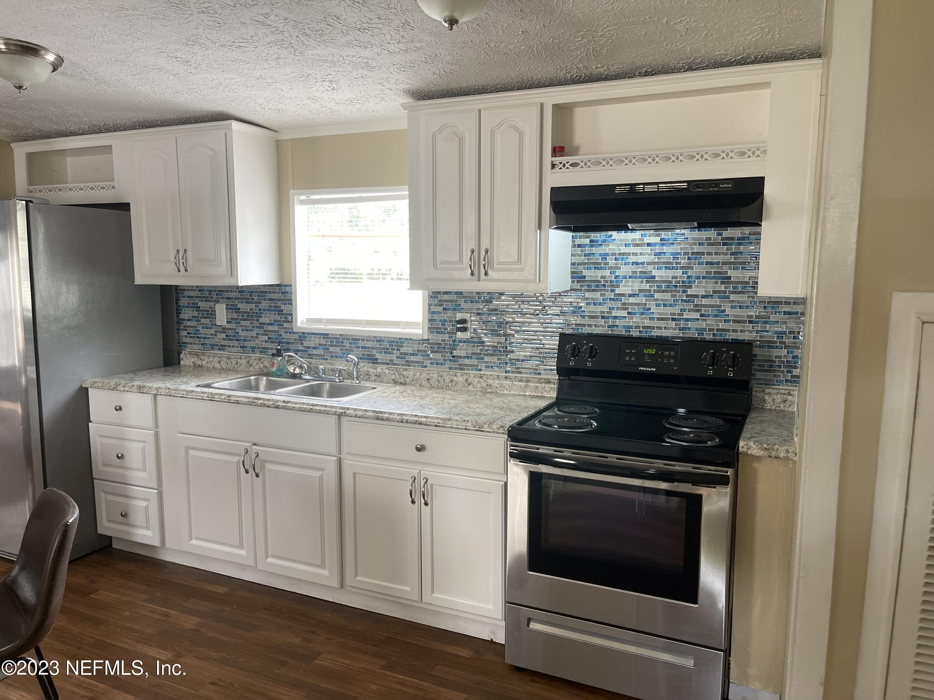 a kitchen with cabinets appliances and a sink