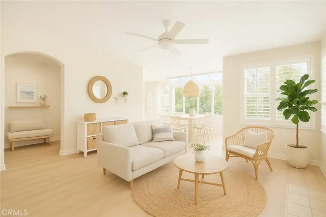 a living room with furniture a window and a potted plant