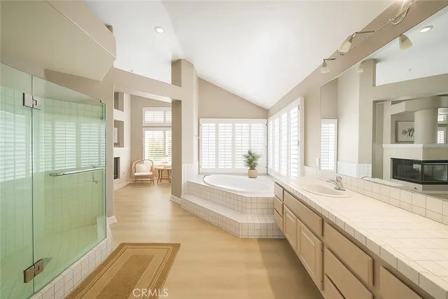 a spacious bathroom with a tub sink and mirror