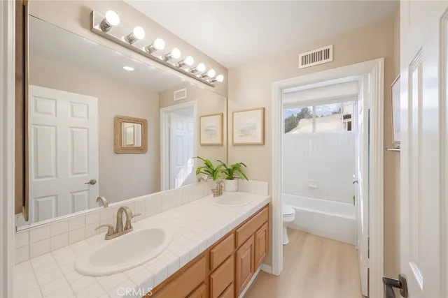 a bathroom with a granite countertop sink a mirror and a bathtub