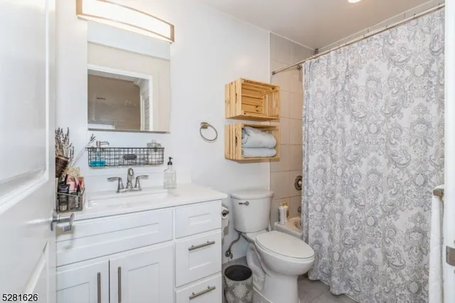 a bathroom with a sink mirror vanity and toilet