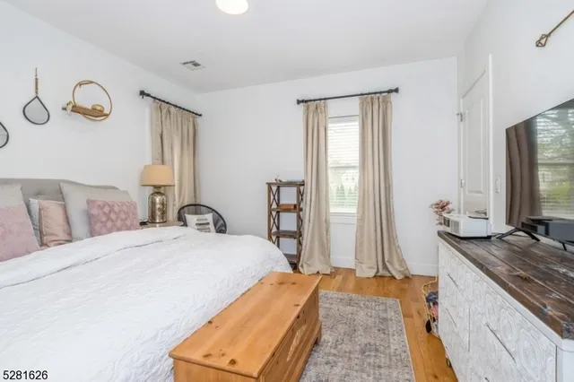 a bedroom with a large bed and a flat tv screen on dresser