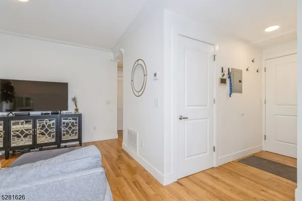 a view of a hallway with workspace and wooden floor