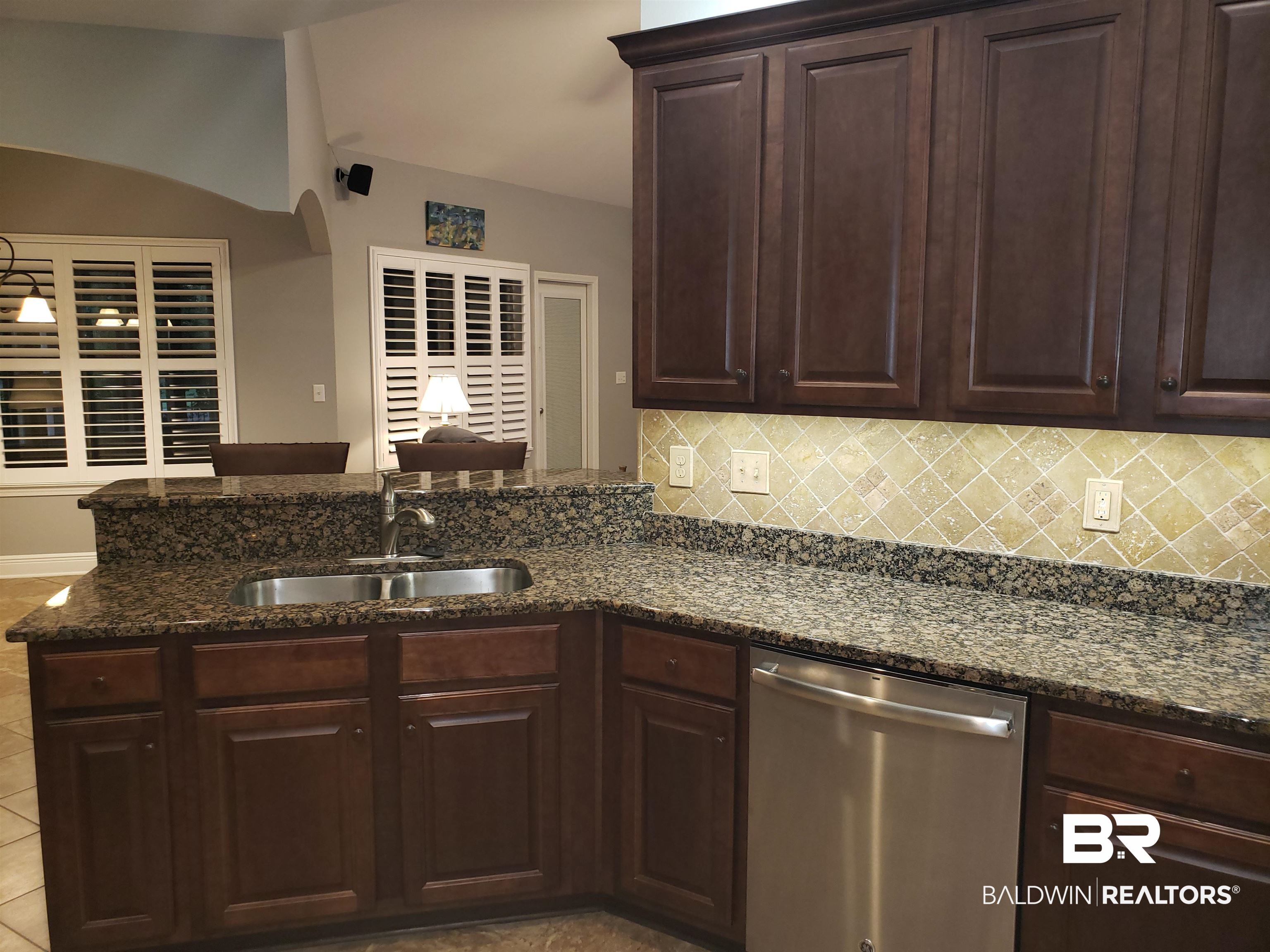 23373 Dundee Circle Foley, AL 36535 - Photo 9 of 34 Kitchen featuring light tile patterned floors, granite counters, stainless steel dishwasher, dark brown cabinetry, and sink