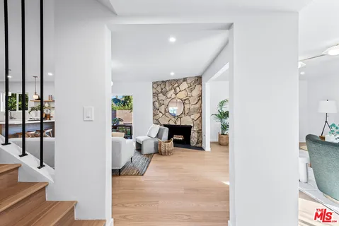 a living room with furniture a fireplace and a potted plant