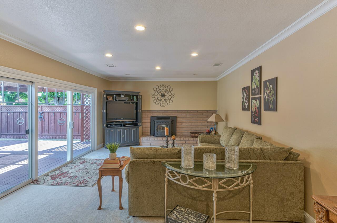 1239 Ayer Drive Gilroy, CA 95020 - Photo 19 of 39 a living room with furniture a flat screen tv and a floor to ceiling window