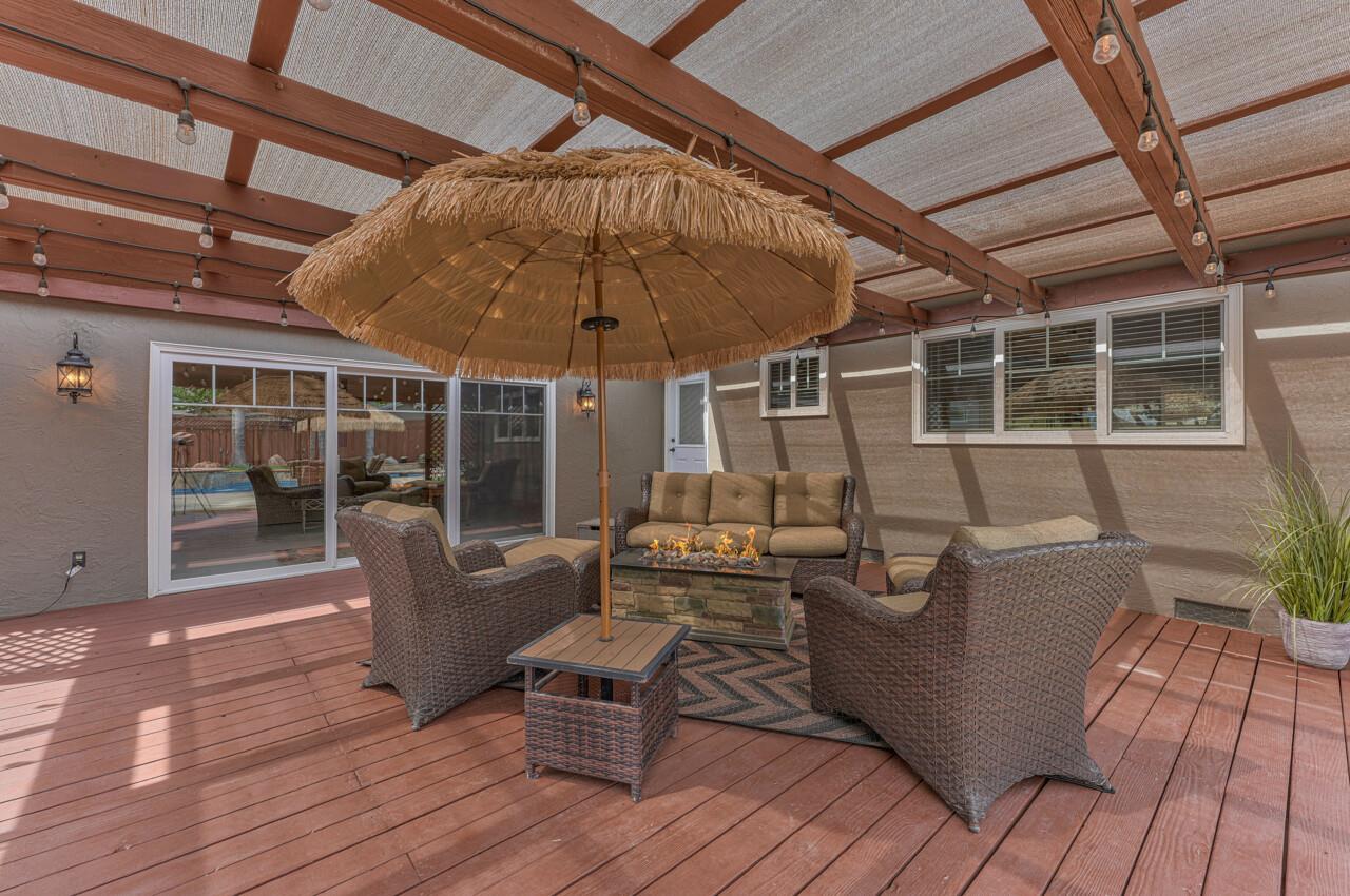 1239 Ayer Drive Gilroy, CA 95020 - Photo 22 of 39 a view of a roof deck with table and chairs under an umbrella with wooden floor