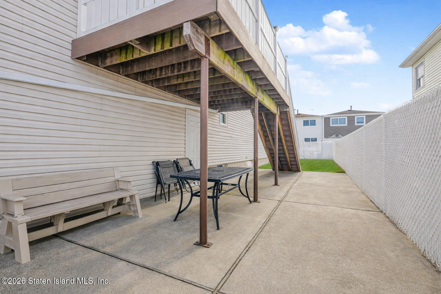 76 Berry Avenue Staten Island, NY 10312 - Photo 37 of 42 a view of a patio with table and chairs with wooden floor and fence