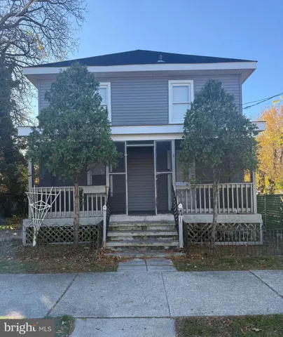a view of a house with a small yard and wooden fence