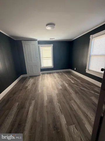 a view of empty room with window and wooden floor