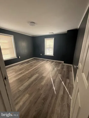 a view of empty room with window and wooden floor