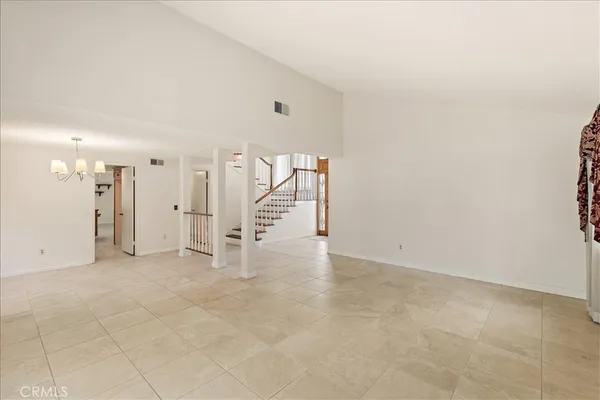a view of a hallway with entryway door with chandelier