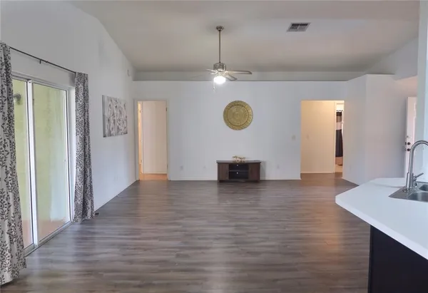 a view of a kitchen with a sink a microwave and wooden floor