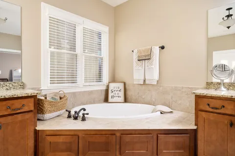a bathroom with a granite countertop sink and a window