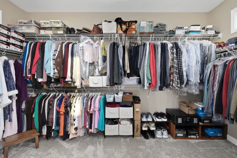 a view of walk in closet with clothes