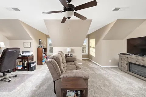 a living room with furniture a flat screen tv and gym equipment