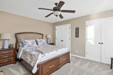 a bedroom with a bed and a ceiling fan