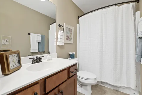 a bathroom with a sink a toilet and shower curtain