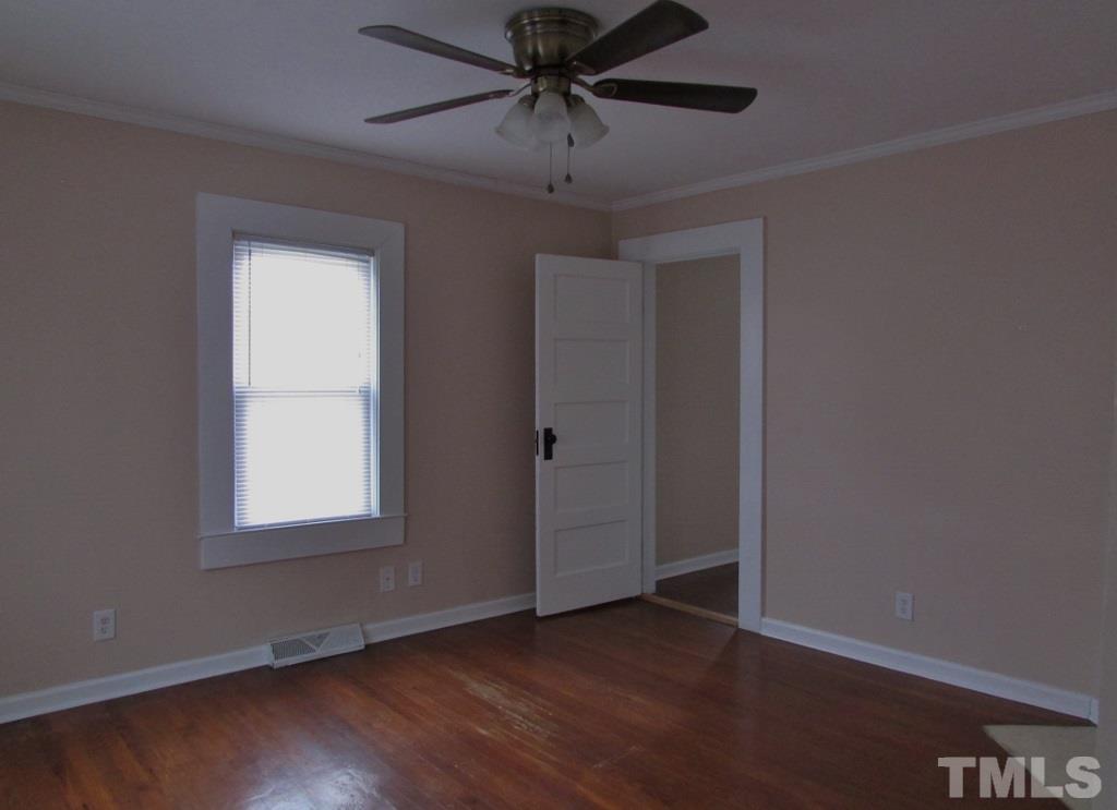 414 McGhees Mill Road Roxboro, NC 27574 - Photo 13 of 22 an empty room with wooden floor chandelier fan and windows