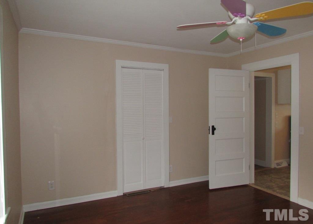 414 McGhees Mill Road Roxboro, NC 27574 - Photo 9 of 22 an empty room with wooden floor and fan