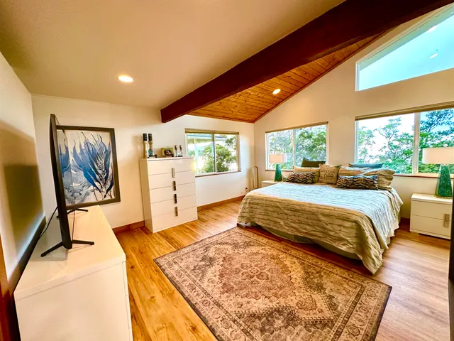 a bedroom with a bed and a large window