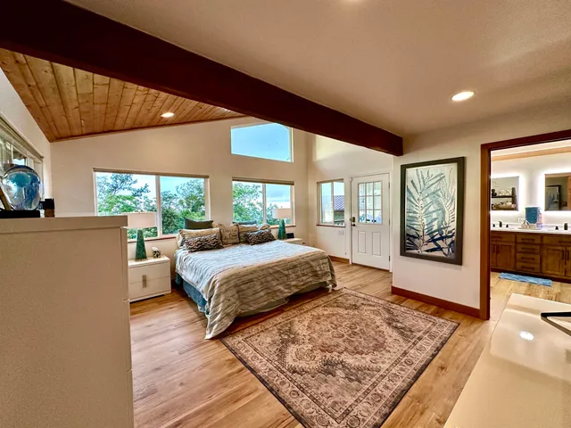 a bed sitting in a spacious bedroom next to a window