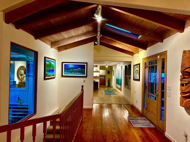 a view of a hallway with wooden floor and windows