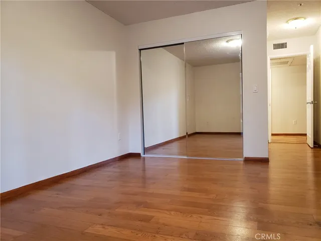 an empty room with wooden floor and entrance