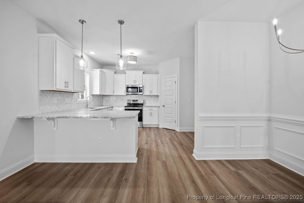 1004 Rhum Drive Fayetteville, NC 28311 - Photo 11 of 34 a open kitchen with white cabinets and wooden floor