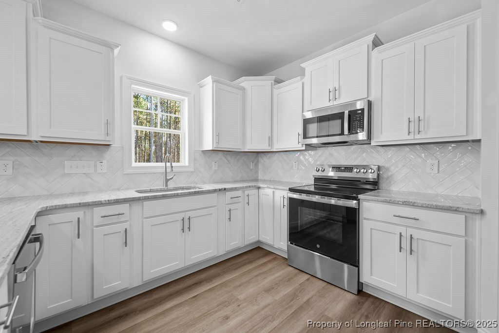1004 Rhum Drive Fayetteville, NC 28311 - Photo 12 of 34 a kitchen with granite countertop white cabinets white stainless steel appliances and sink