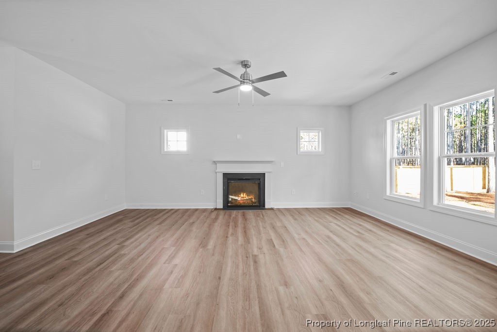 1004 Rhum Drive Fayetteville, NC 28311 - Photo 8 of 34 an empty room with wooden floor fireplace and windows