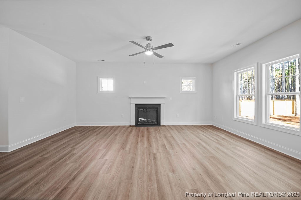 1004 Rhum Drive Fayetteville, NC 28311 - Photo 9 of 34 an empty room with wooden floor fireplace and windows