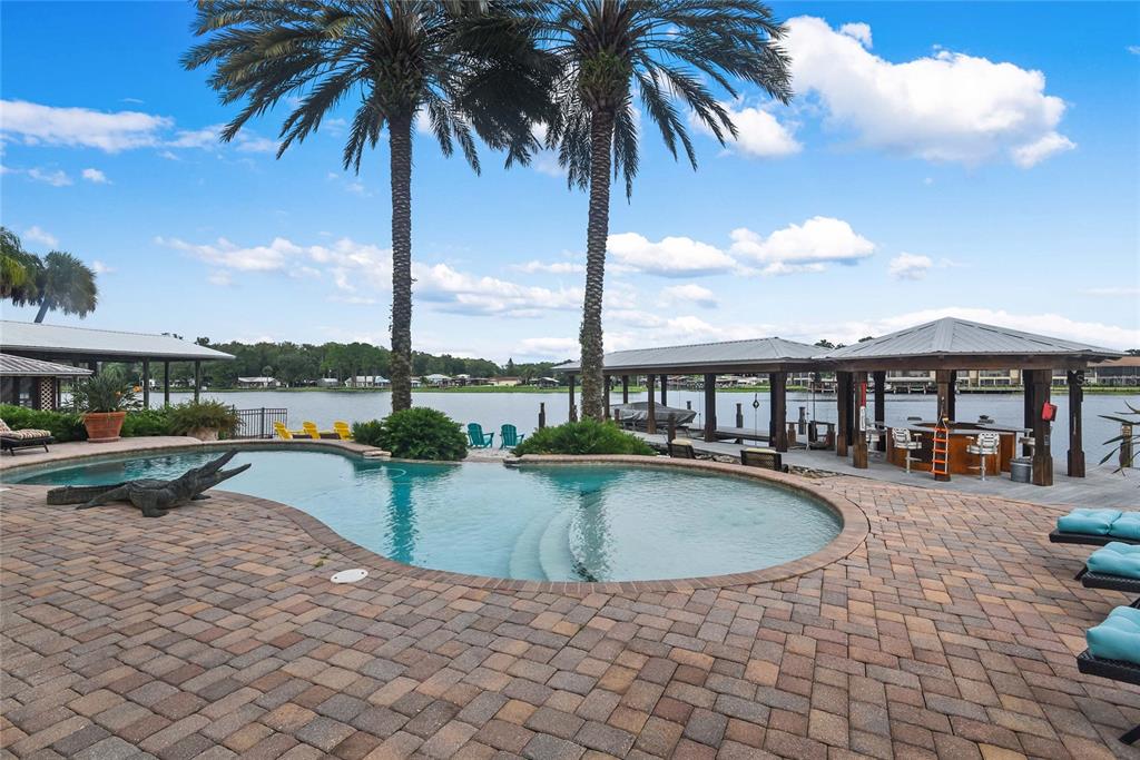 56230 Redbud Road Astor, FL 32102 - Photo 25 of 44 a view of swimming pool with outdoor seating and a garden