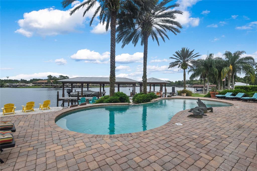 56230 Redbud Road Astor, FL 32102 - Photo 3 of 44 a view of a swimming pool and lounge chair